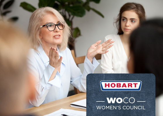 Office meeting highlighting HOBART Women’s Council (WOCO), an initiative promoting women and equality within the company. Documents and writing materials are on the table.